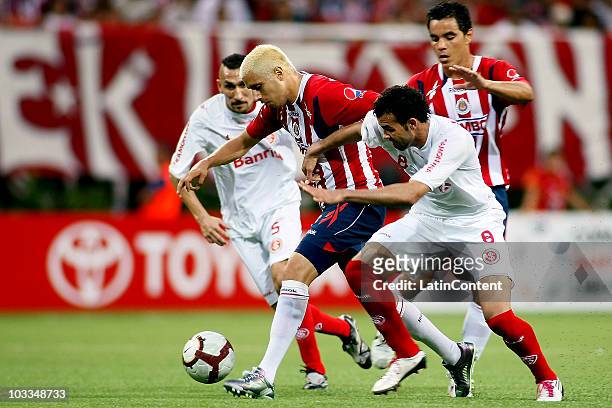 Adolfo Bautista of Chivas struggles for the ball with Sergio Guimaraes of Internacional during the final match of the 2010 Copa Santander...