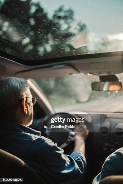 ervaren oudere man met glazen schijven een auto - car sunroof stockfoto's en -beelden