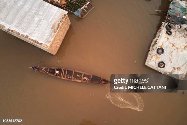 Malian fisherman throws his fishing net next to his flooded village on the outskirts of the capital Bamako, on September 14, 2018. Due to heavy rains...