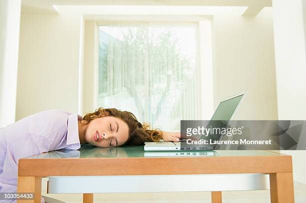 young woman asleep with laptop at home - fatigué photos et images de collection