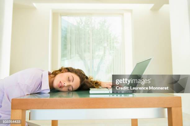 young woman asleep with laptop at home - sleeping table stock pictures, royalty-free photos & images