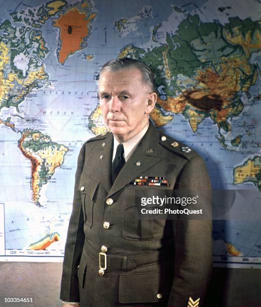 Portrait of General George C. Marshall , General of the Army, standing in front of a world map, Washington, DC, 1945.