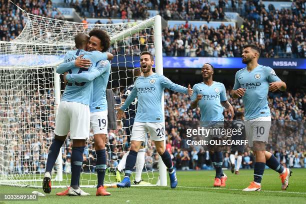 Manchester City's German midfielder Leroy Sane celebrates with Manchester City's Brazilian midfielder Fernandinho after scoring during the English...