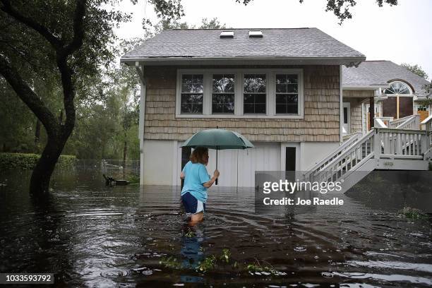 Kim Adams makes her way to her home that is surrounded by flood waters after Hurricane Florence passed through the area on September 15, 2018 in...
