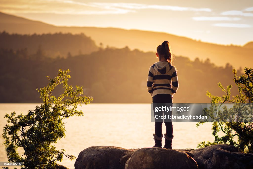 Girl watching sunset over Lake Derwentwater near Keswick, England