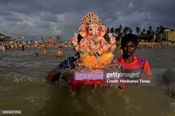 People carry and immerse the idols of Hindu God Ganesha on the first day of Ganpati Visarjan at Juhu Beach, on September 14, 2018 in Mumbai, India....