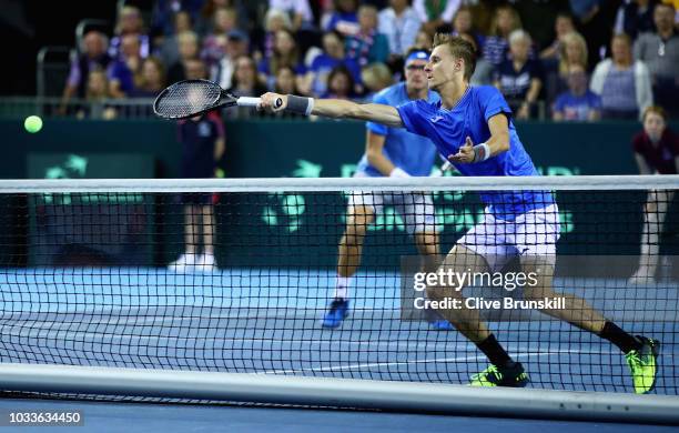 Denis Istomin of Uzbekistan stretches to play forehand watched by team mate Sanjar Fayziev during day two of the Davis Cup by BNP Paribas World Group...