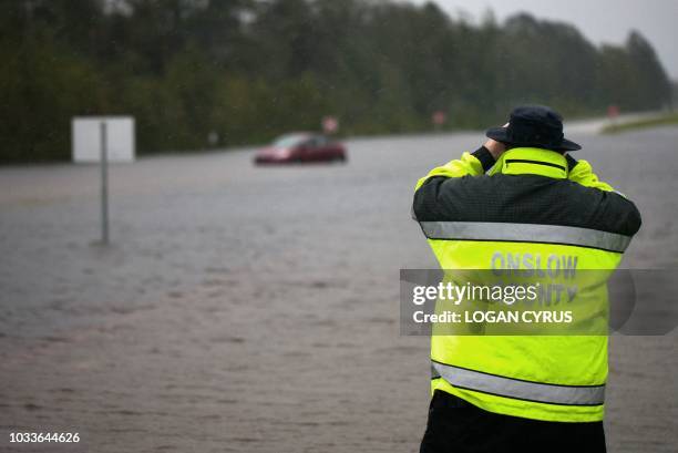 Members of Onslow County emergency look to see if a passenger was still in a car that was overtaken by flooding on US Route 17 outside of...