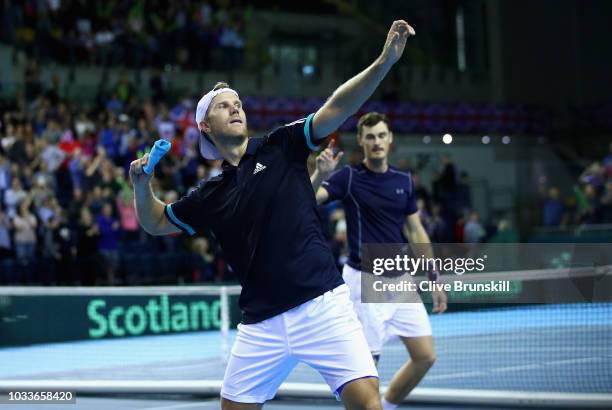 Dominic Inglot of Great Britain throws his wrist band to the crowd watched by his doubles partner Jamie Murray after they had celebrated match point...