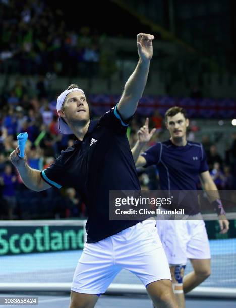 Dominic Inglot of Great Britain throws his wrist band to the crowd watched by his doubles partner Jamie Murray after they had celebrated match point...