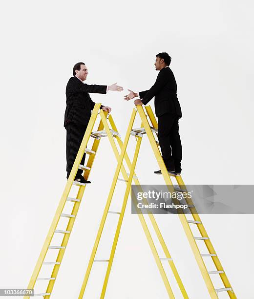 two businessmen about to shake hands on a ladder - suit and tie stock pictures, royalty-free photos & images