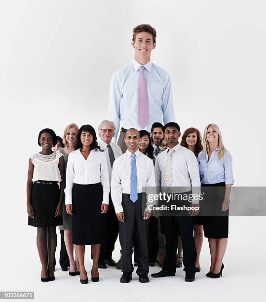 businessman standing out from the crowd - crowd looking into camera happy indian stock-fotos und bilder