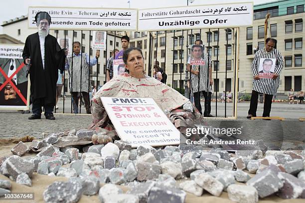 Demonstrator dressed as a victim of a stoning execution joins Iranian exiles protesting against stoning and condemns the forced concessions in front...