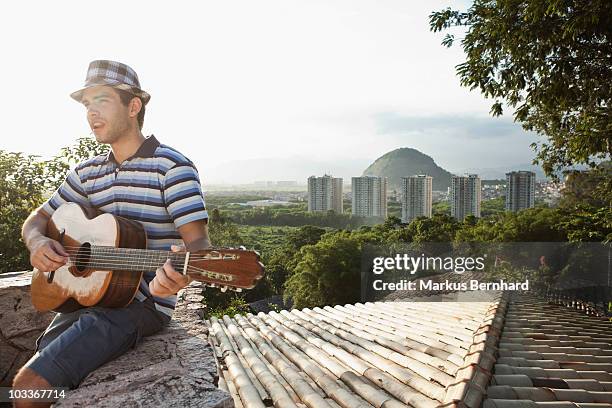 young man playing guitar on rooftop. - 60161 imagens e fotografias de stock