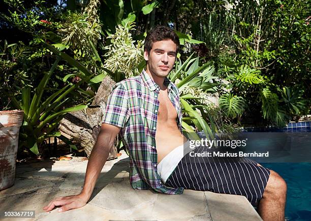 young man sitting at pool side - 60161 imagens e fotografias de stock