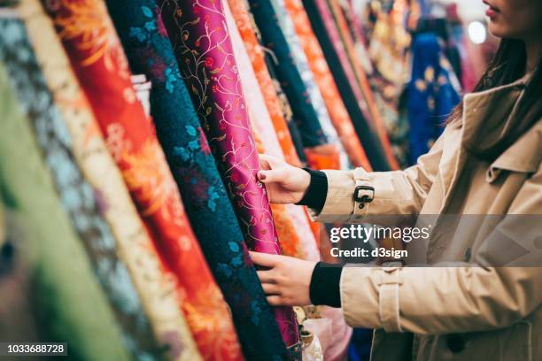 fashion designer shopping for colourful fabrics in fabric store - art product photos et images de collection