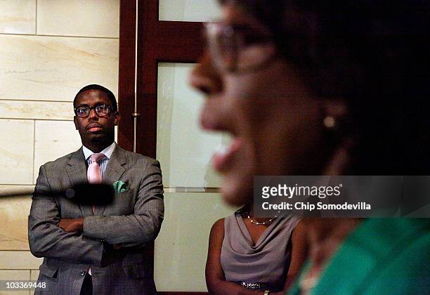Mikael Moore , chief of staff and grandson of Rep. Maxine Waters , listens to Waters address a news conference to challenge the charges made against...