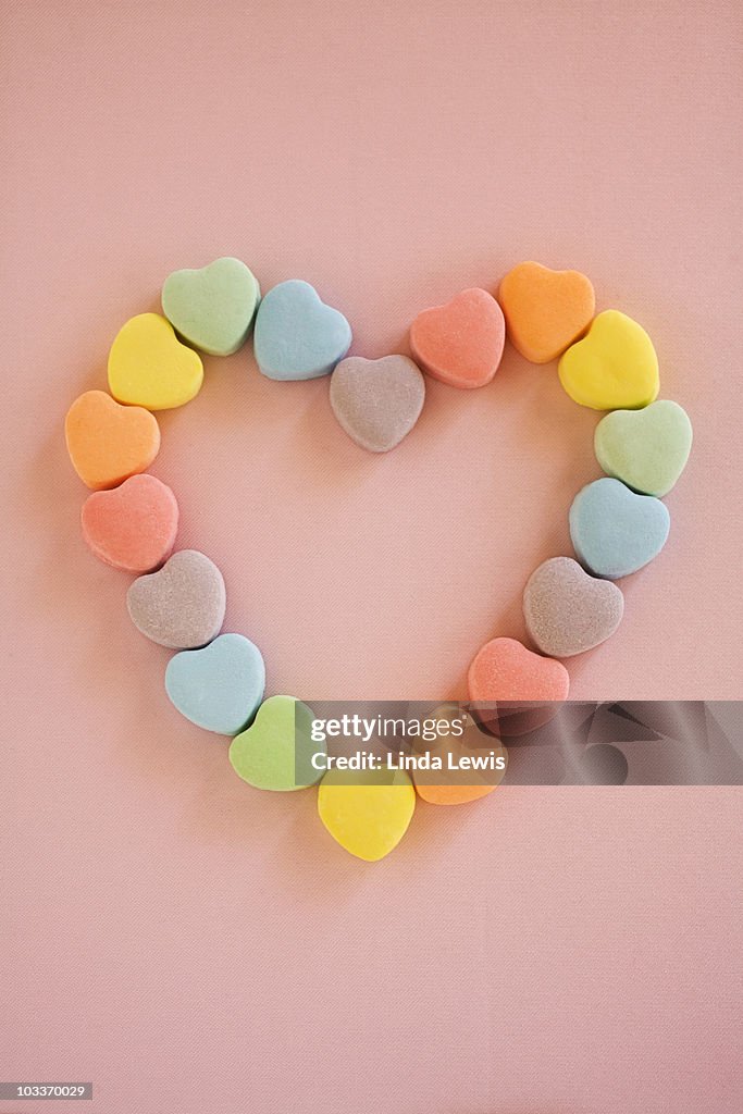 Valentine candy hearts in a heart shape.