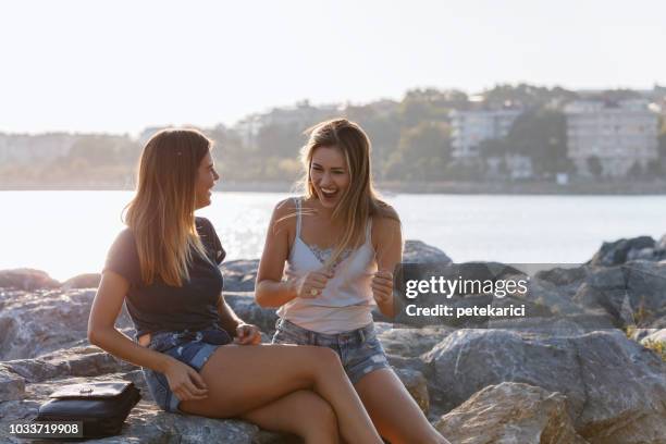 two happy friends talking at the seaside - 20 cigarette stock pictures, royalty-free photos & images