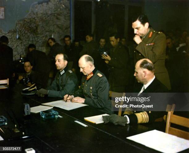 German military commander Generaloberst Alfred Jodl signs the German Instrument of Surrender, Reims, France, May 7, 1945. Seated on his right is...