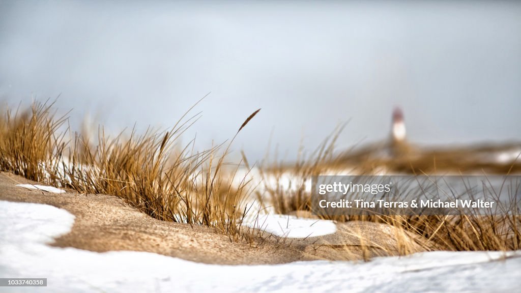Snow covered dunes with lighthouse on the Isle of Sylt in winter