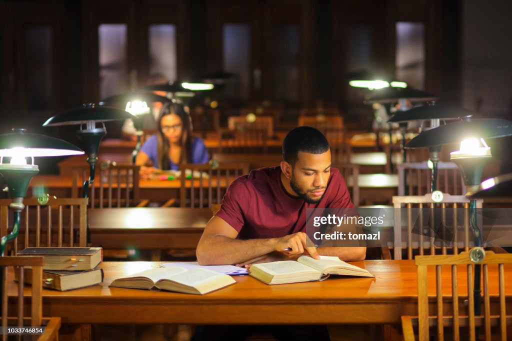 Young afro-american man studying in the library