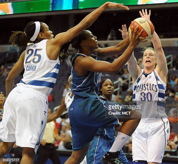 Minnesota Lynx guard Monica Wright, center, drives for a shot between Washington Mystics defenders Monique Currie and Katie Smith during the first...