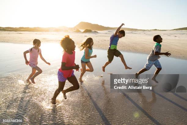 children playing on a beach at sunset - african girls on beach stockfoto's en -beelden