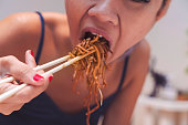 Asian woman eating noddle by chopsticks  - close up