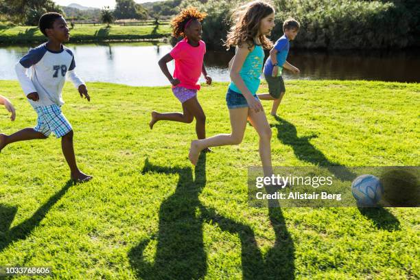 children playing soccer together - barefeet soccer stock pictures, royalty-free photos & images