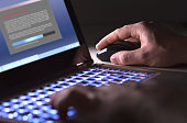 Man installing software in laptop in dark at night. Hacker loading illegal program or guy downloading files.