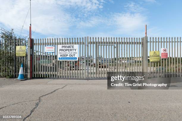 palisade security gate and fence with warning signs. - border control stock pictures, royalty-free photos & images