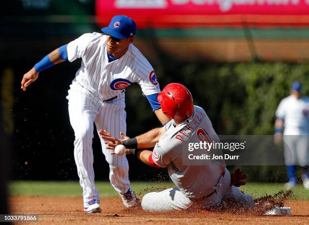 Jose Peraza of the Cincinnati Reds steals second base as Addison Russell of the Chicago Cubs is unable to catch the throw from Willson Contreras...