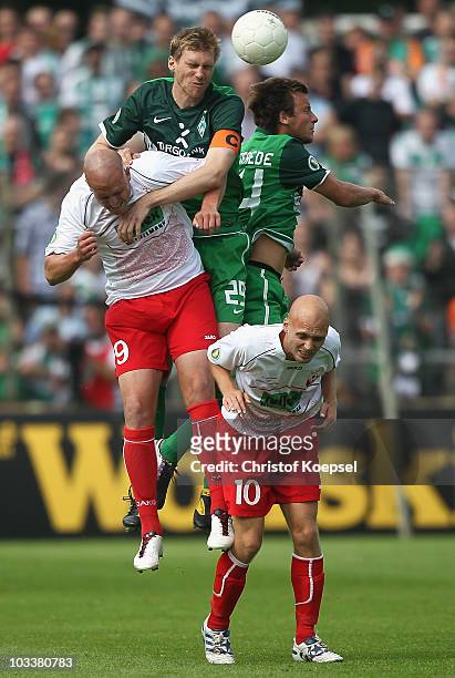 Christian Knappmann of Ahlen, Per Mertesacker and Philipp Bargfrede of Bremen and Nils Ole Book of Ahlen go up for a header during the DFB Cup first...