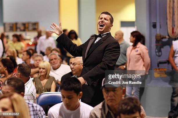 Auction ringman, Brett Baugh, reacts while taking bids during the Fannie Mae foreclosed home auction at the Miami Beach Convention Center on August...