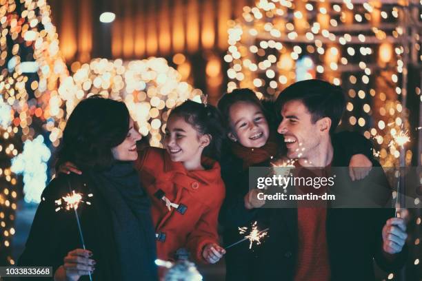 op kerstmis met het branden van wonderkaarsen en gelukkige familie - new years 2018 stockfoto's en -beelden