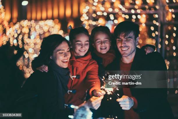 glückliche familie an weihnachten mit brennenden wunderkerzen - alter wunsch fürs neue jahr stock-fotos und bilder