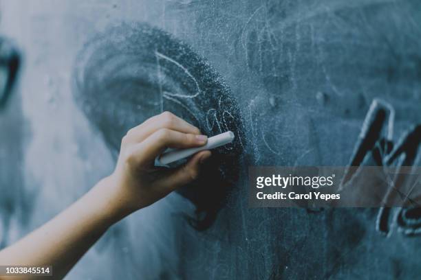 hands writing in chalkboard - chalkboard stock pictures, royalty-free photos & images