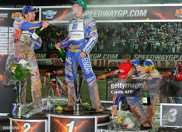 1st placed Rune Holta of Poland is sprayed with champagne by 2nd Jason Crump, of Australia while 3rd Tomasz Gollob, of Poland ducks after the FIM...