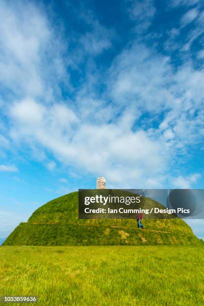 man walking up thufa grassy dome with fish drying house on top (art installation by olof nordal) - installation art stock-fotos und bilder