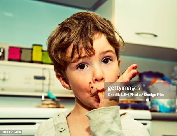 a young boy licking fingers after making fudge - licking finger stock pictures, royalty-free photos & images
