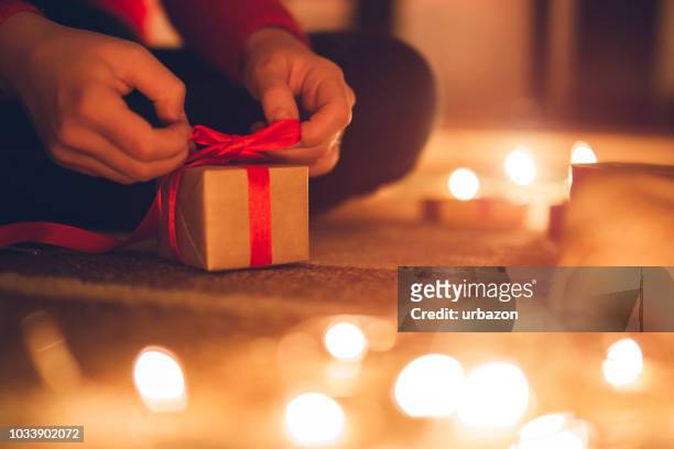 woman wrapping gifts for christmas - present luminoso imagens e fotografias de stock