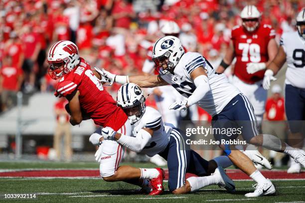 Chris Wilcox and Isaiah Kaufusi of the BYU Cougars make a tackle against Danny Davis III of the Wisconsin Badgers in the first quarter of the game at...