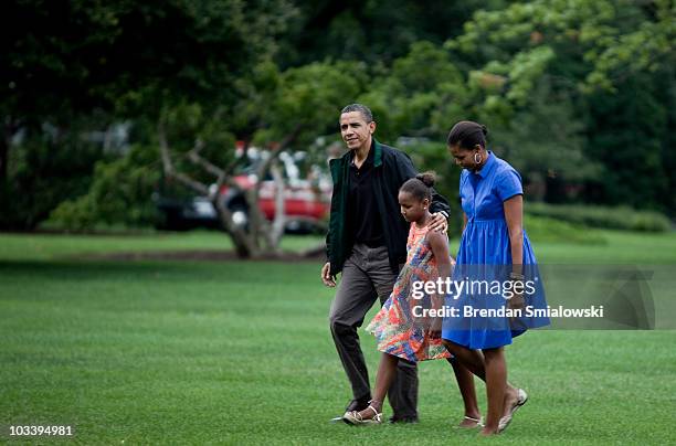 President Barack Obama with daughter Sasha Obama and first lady Michelle Obama walks from Marine One on the South Lawn of the White House August 15,...