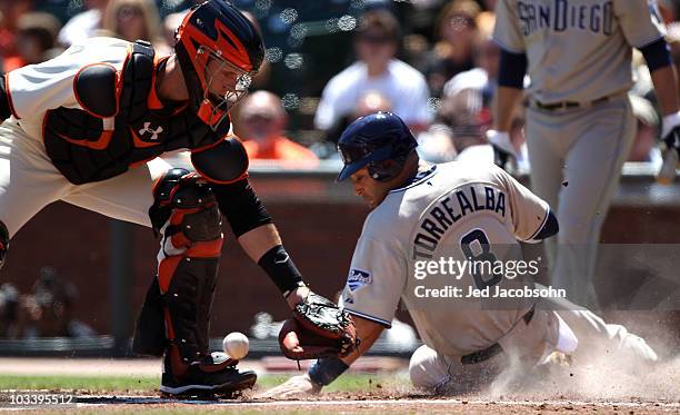 Yorvit Torrealba of the San Diego Padres slides safely past Buster Posey of the San Francisco Giants on a single in the second inning by Everth...