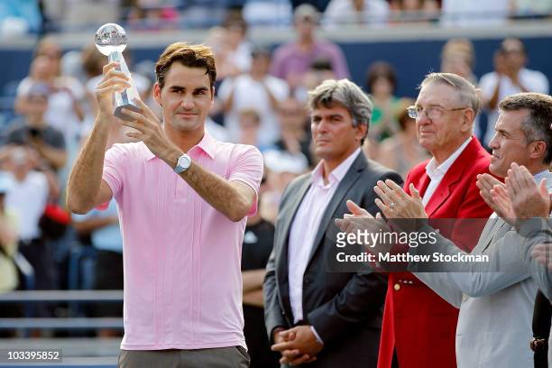 Roger Federer of Switzerland is presented the runner-up trophy after loosing to Andy Murray of Great Britain during the final of the Rogers Cup at...
