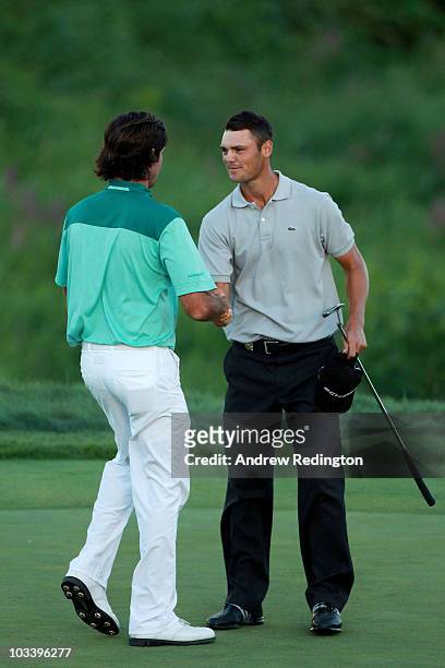 Martin Kaymer of Germany shakes hands with Bubba Watson on the 18th green after defeating Watson during the three-hole aggregate playoff following...