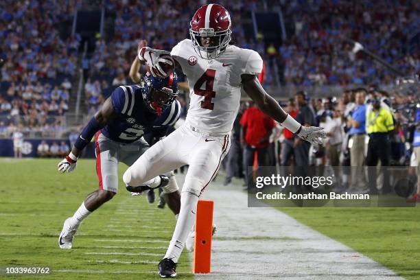 Jerry Jeudy of the Alabama Crimson Tide runs with the ball as Montrell Custis of the Mississippi Rebels defends during the first half at...