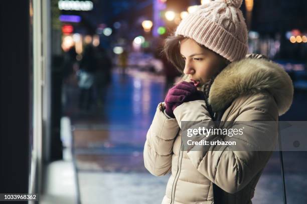 woman is feeling cold downtown - shivering stock pictures, royalty-free photos & images