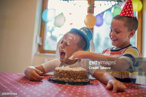 boy with a fun hat celebrating his birthday with his loved ones - absurd birthday stock pictures, royalty-free photos & images